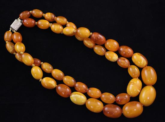 A double strand graduated oval amber bead necklace, gross weight 104 grams.